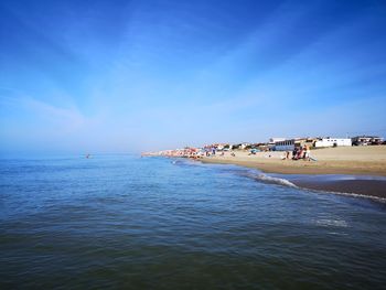 People on beach against blue sky