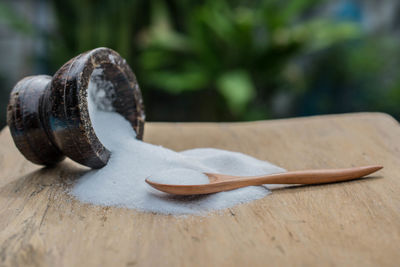 Close-up of salt and wooden spoon on cutting board