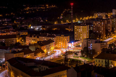 High angle view of illuminated street amidst buildings at night