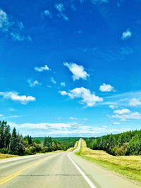 Empty road along landscape against blue sky