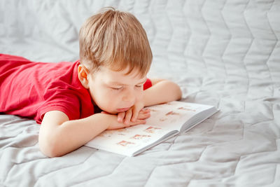 Cute boy lying on bed at home