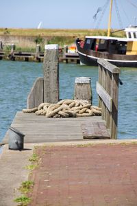 Sailboats moored on pier by sea