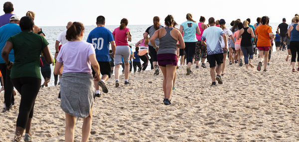 Rear view of people walking on beach