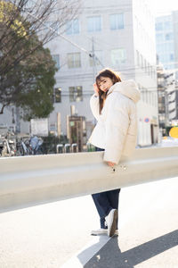 Portrait of young woman walking on street in city