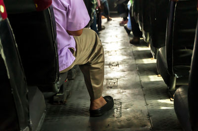 Low section of people sitting on a passenger seat in a bus