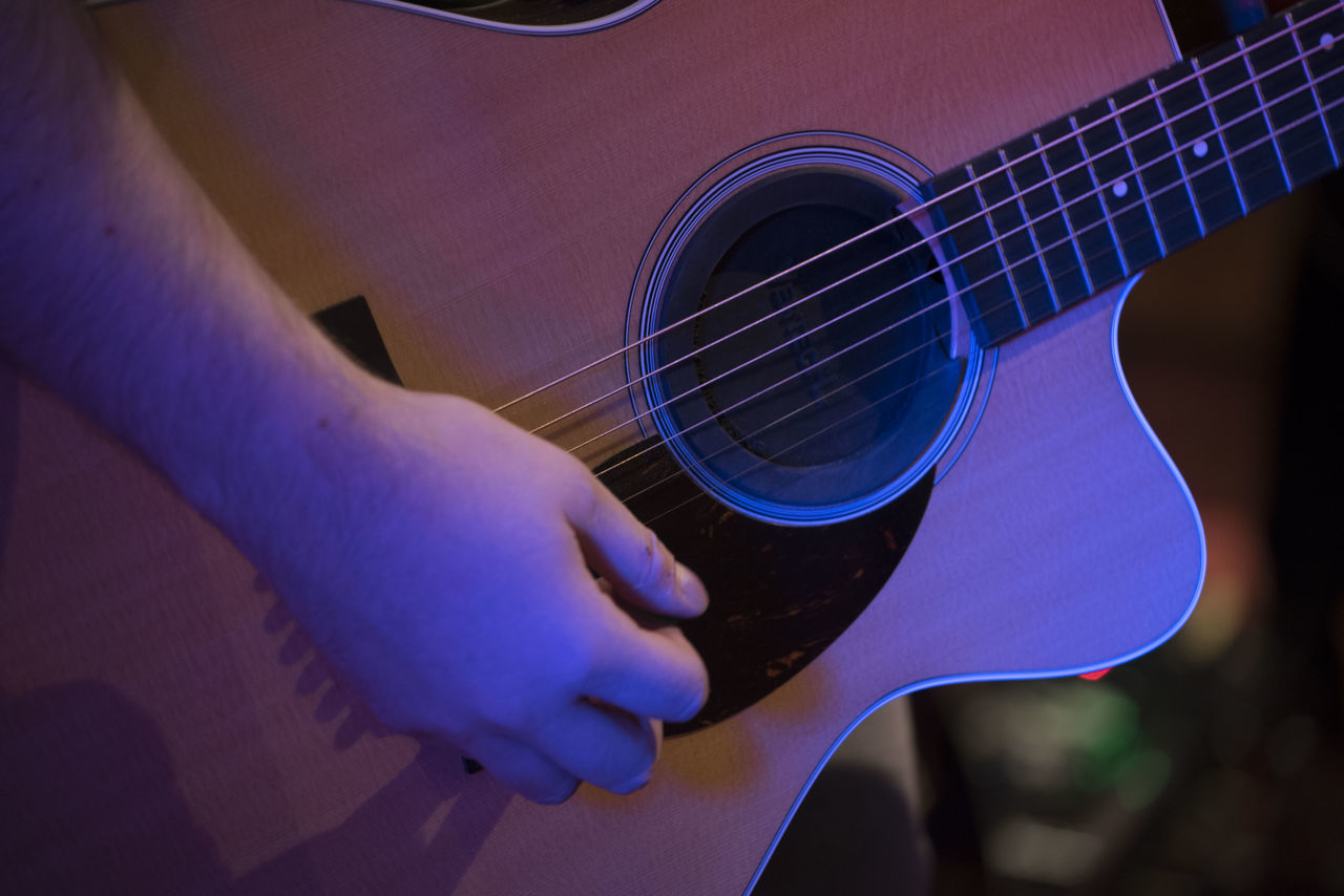 CLOSE-UP OF HAND HOLDING GUITAR PLAYING