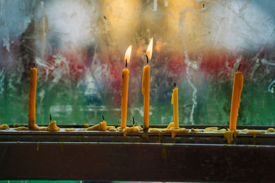 Close-up of lit candles on temple outside building
