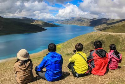 Rear view of people sitting on mountain