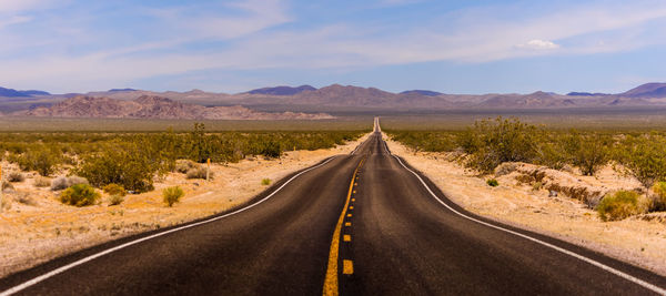 Road passing through landscape against sky