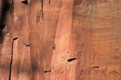 Distant view of hiker climbing mountain