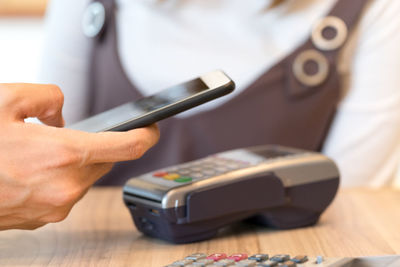 Close-up of person using mobile phone on table