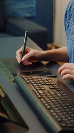 Midsection of woman using laptop at table