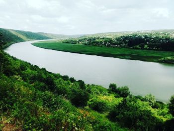 Scenic view of river against cloudy sky