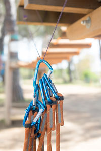 Safety harnesses hanging on string against suspension bridge at park