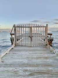 Wooden pier on sea against sky