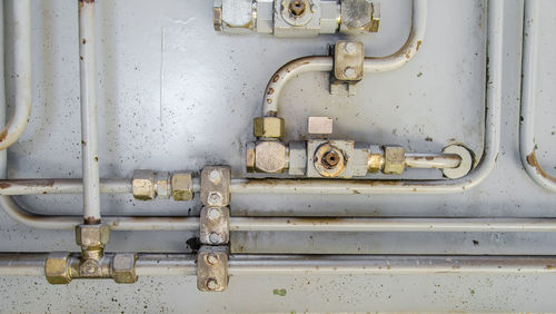 Close-up of pipe connection attached on wall in factory