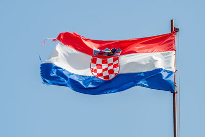 Low angle view of flag against clear sky
