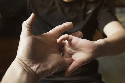 Father and son locking fingers at home