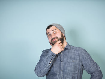 Young man looking away against white background