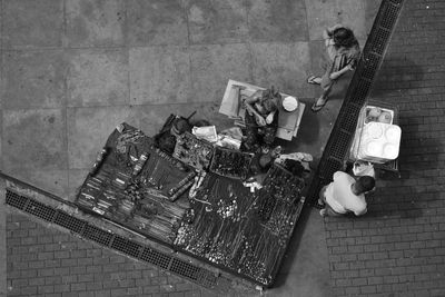 Directly above shot of female vendor selling necklaces on sidewalk