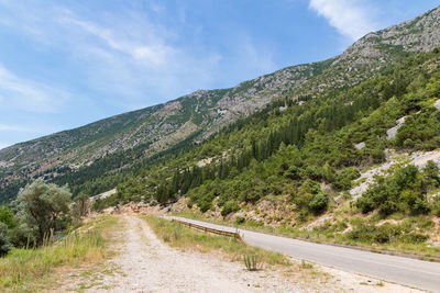 Road leading towards mountains against sky