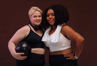 Portrait of smiling women against brown background