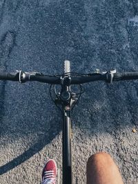 Low section of person riding bicycle on road