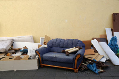 View of damaged blue sofa next to wall