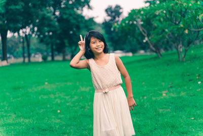 Portrait of smiling woman standing on field