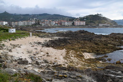 Scenic view of sea by buildings against sky