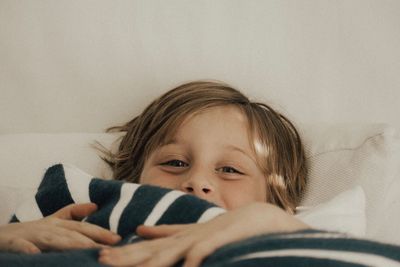 Close-up of cute girl relaxing on bed at home