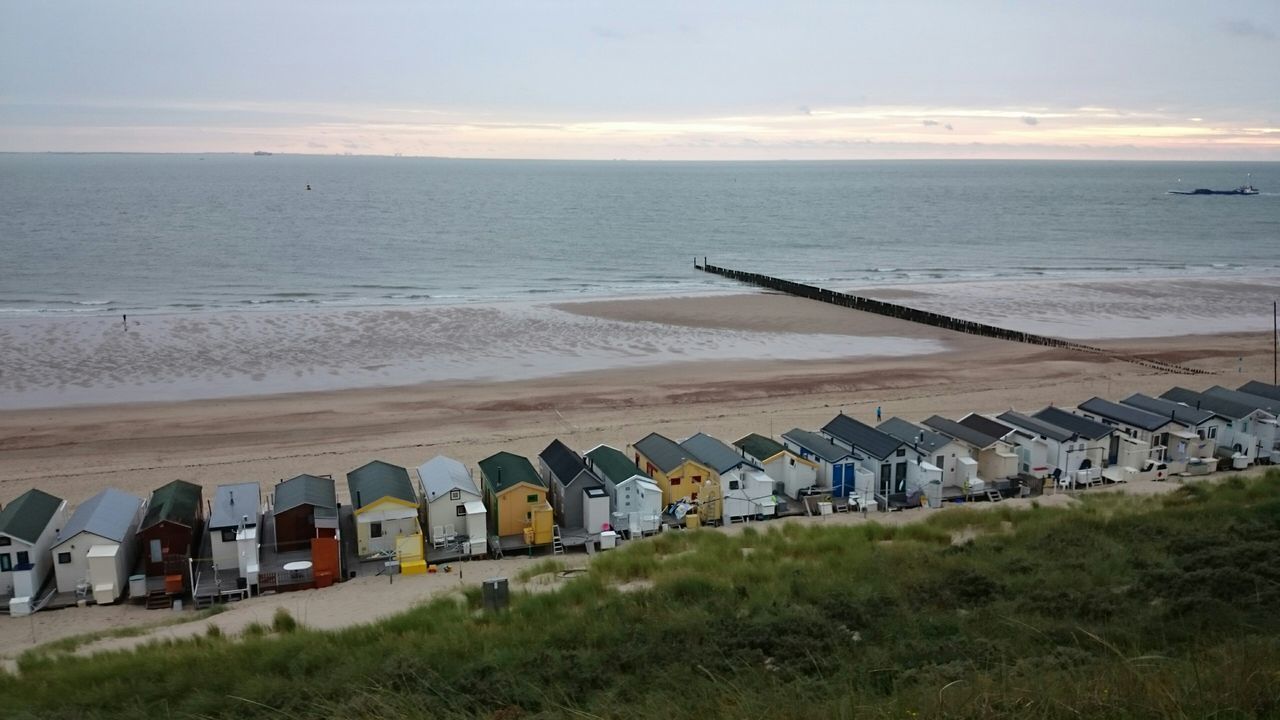 sea, horizon over water, beach, water, sky, built structure, shore, architecture, sand, building exterior, cloud - sky, nature, scenics, tranquil scene, coastline, tranquility, outdoors, beauty in nature, incidental people, cloud