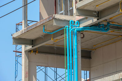 Low angle view of construction site against clear blue sky