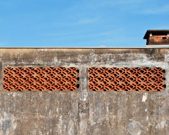 Low angle view of wall against blue sky