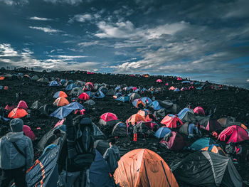 Rear view of people on shore against sky