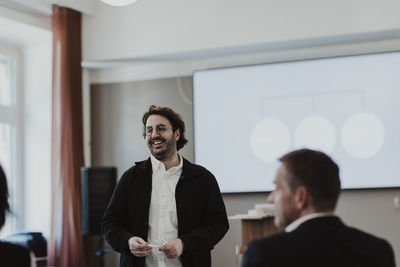 Smiling male entrepreneur talking with employee in education class