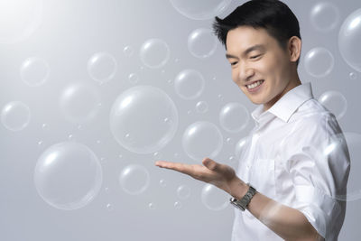 Portrait of smiling boy standing against white background