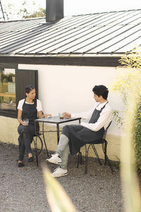 Waitress and waiter taking coffee break outside restaurant