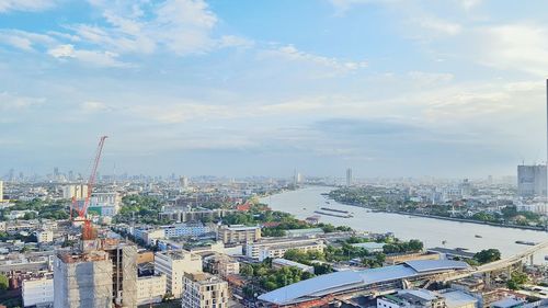 River amidst cityscape against sky