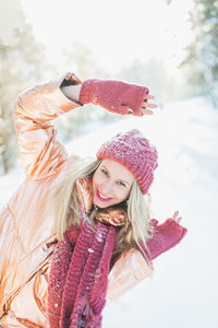 Portrait of smiling young woman using smart phone during winter