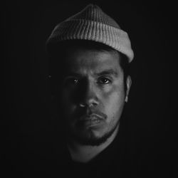 Close-up portrait of young man against black background