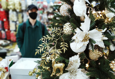 Man with christmas tree in market