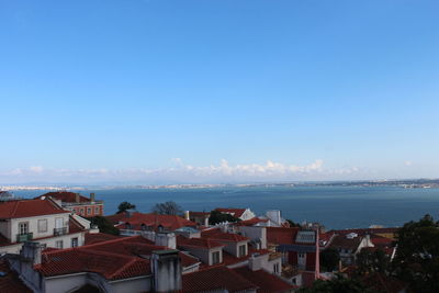 High angle view of townscape by sea against sky