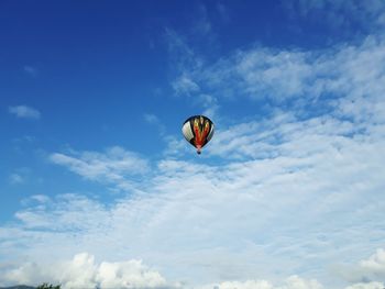 Low angle view of paragliding against blue sky