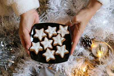 Midsection of woman holding christmas cookies