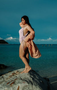 Portrait of young woman standing at beach