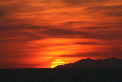 Scenic view of dramatic sky over silhouette landscape