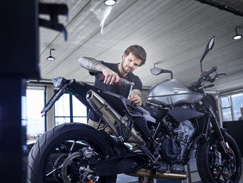 Maintenance engineer repairing motorcycle seat at auto repair shop