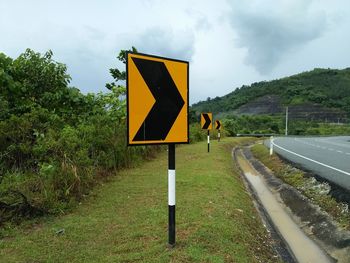 Road sign against sky