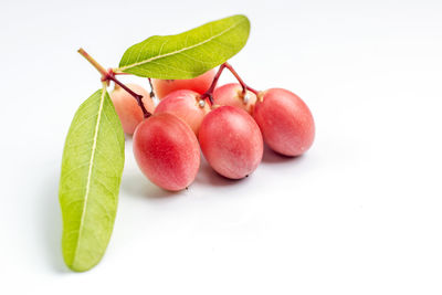 Close-up of fresh fruits and leaves against white background